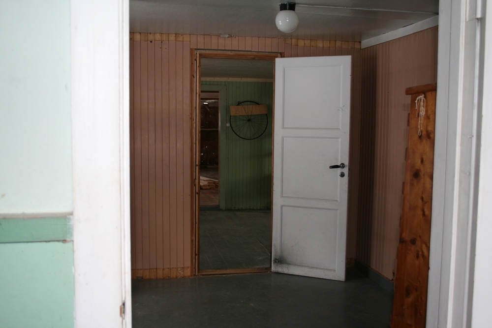 Leirfjord, Nedre-Leland. Bergh-brygga (museum). Ny dør er lagd og satt inn mellom det rosa rommet og lagerrommet med gjenstander i 2. etg. Bildet er tatt i forbindelse med renoveringen av brygga.