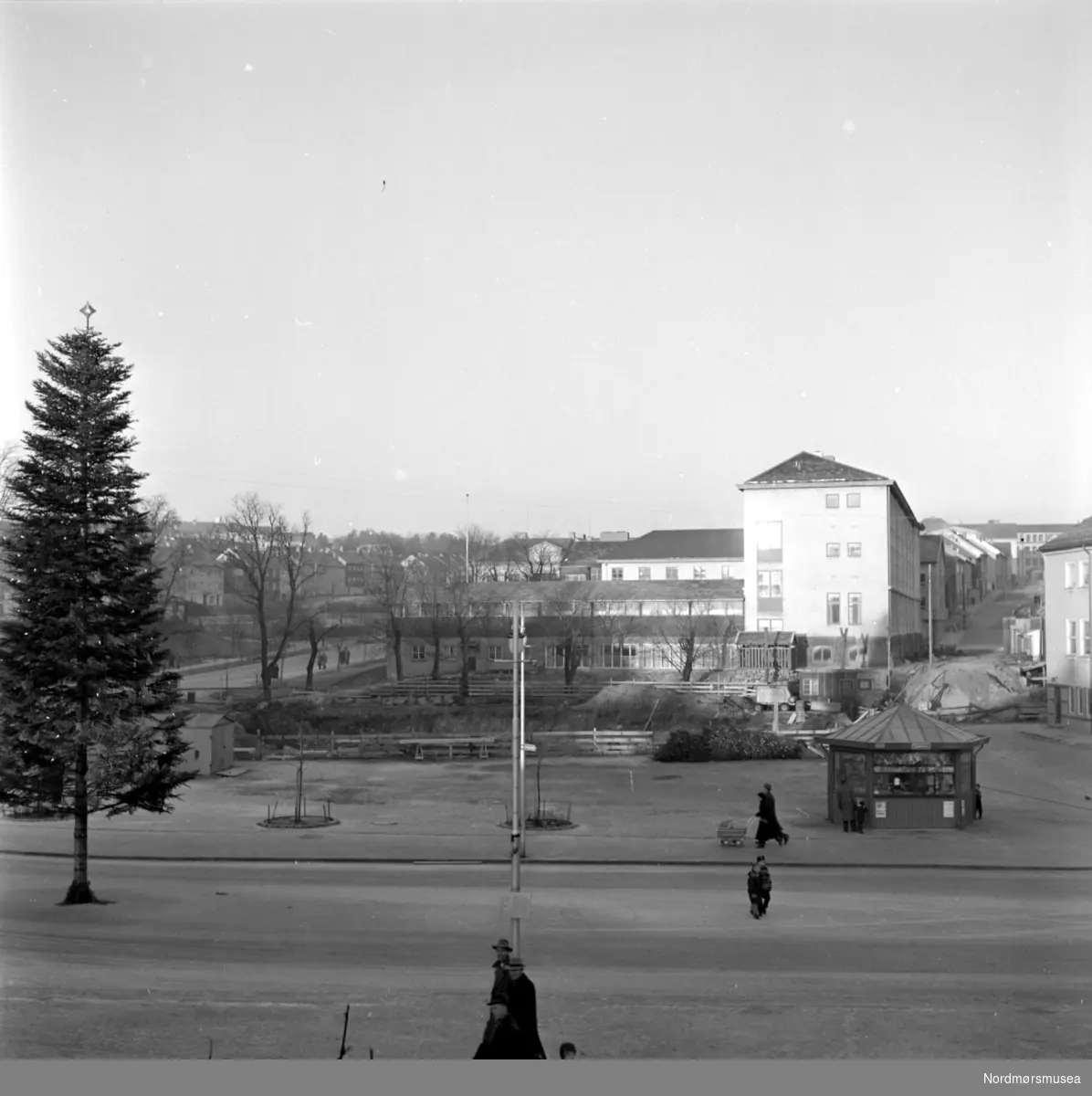 Foto fra Kongens plass hvor snart Folkets hus vil bli reist, på Kirkelandet i Kristiansund. Bildet kan trolig dateres til omkring 1958. Fotograf er Nils Williams. Fra Nordmøre museums fotosamlinger.