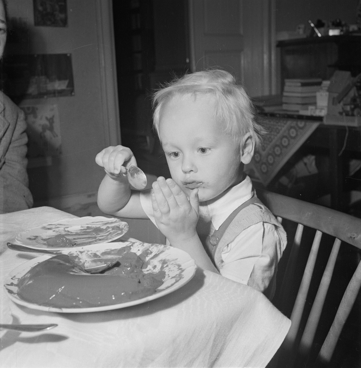 Pojke sitter vid matbordet och äter, Uppsala 1954