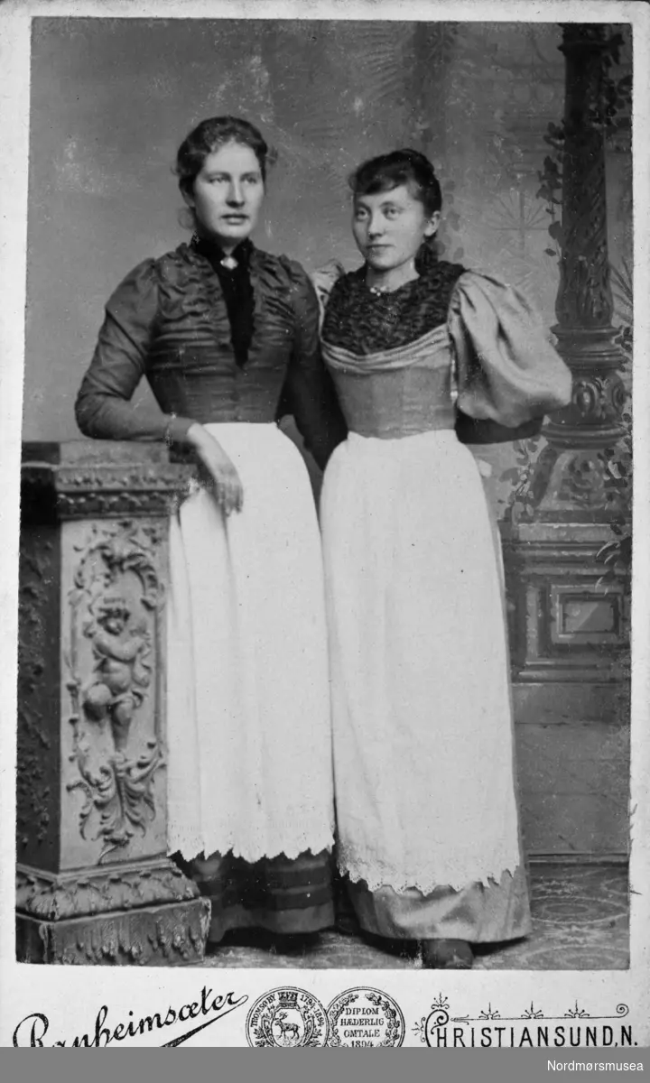 Portrett av to kvinner. Trolig fra Kristiansund. Fra et fotoalbum som stammer etter Marie Opdal (f. april 1894 - d. februar 1981/82), og gitt i gave av Torbjørg og Arild Karijord. Fra Nordmøre museums fotosamlinger.