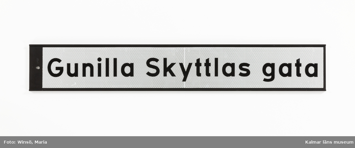 KLM 46157:363. Skylt, vägskylt. Rektangulär vägskylt av metall med text: Gunilla Skyttlas gata.