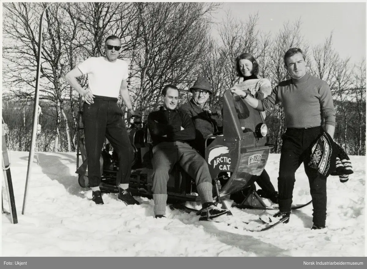 James Coward på snøskuter med merket Arctic cat, datteren Unni Coward står ved siden av sammen med Keith Softby, Eric Turner og Anthony Pratt