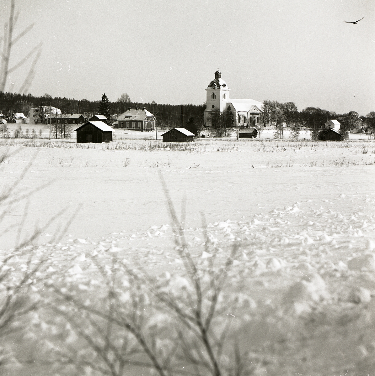 Norrala kyrka med omkringliggande byggnader, 19 januari 1984.