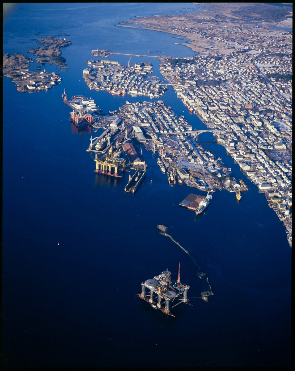 Flyfoto av Haugesund med Risøy og flere rigger i sentrum.