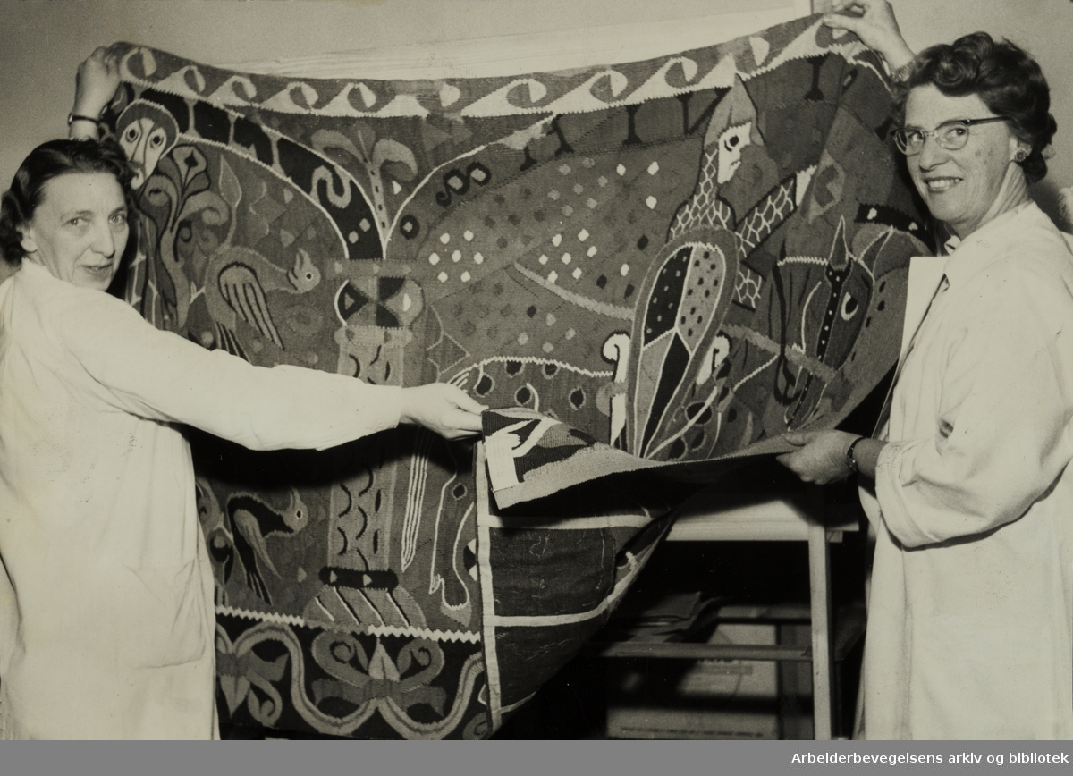 Kunstindustrimuseet. Baldisholteppet som er 800 år gammelt vises fram av tekstilkonservator Elsa Tharaldsen og assistent Liv Grosvold. Mars 1958
