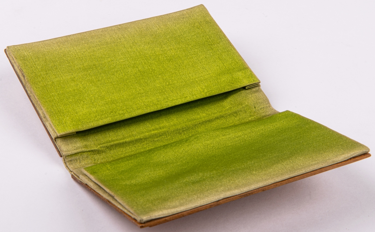 Bok för visitkort med träpärm med skuren uddsnittsdekor. Inuti klädd med grönt siden.