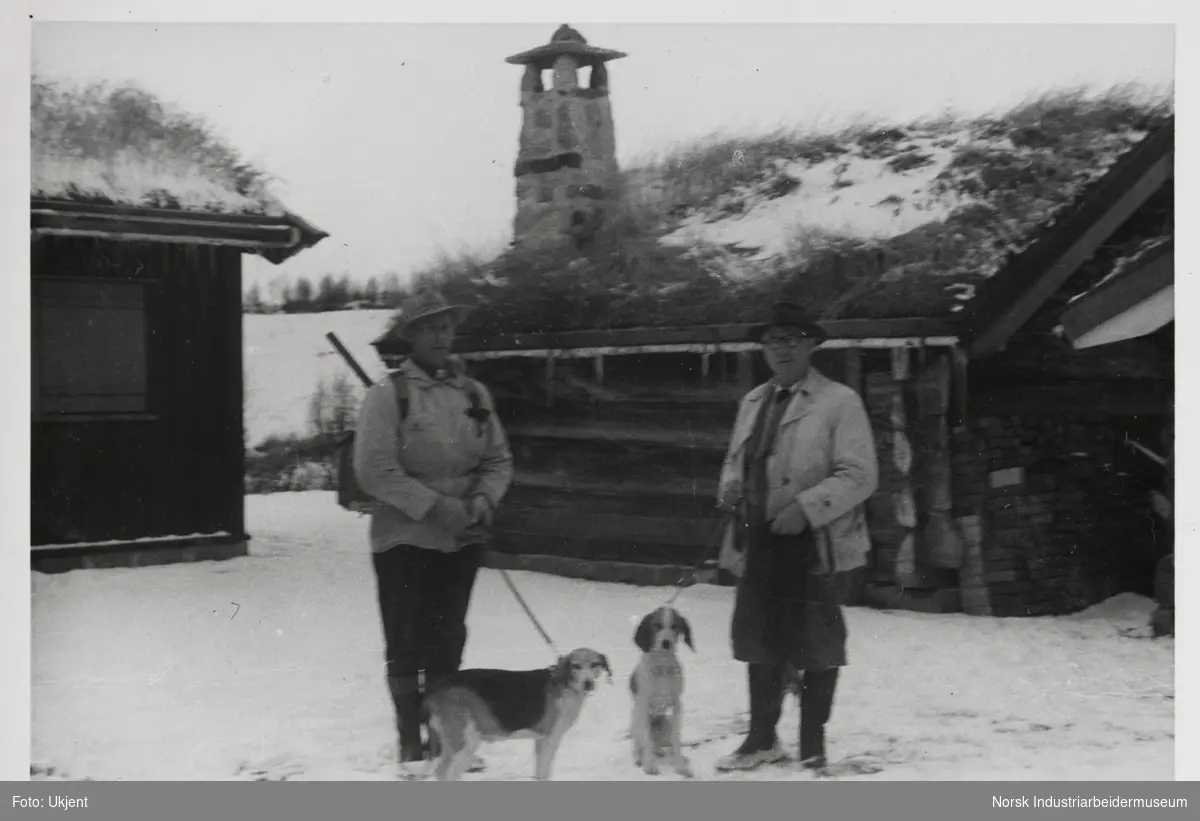 James Coward og venn med to hunder står i snøen på hyttetunet på Sundet, Møsstrond