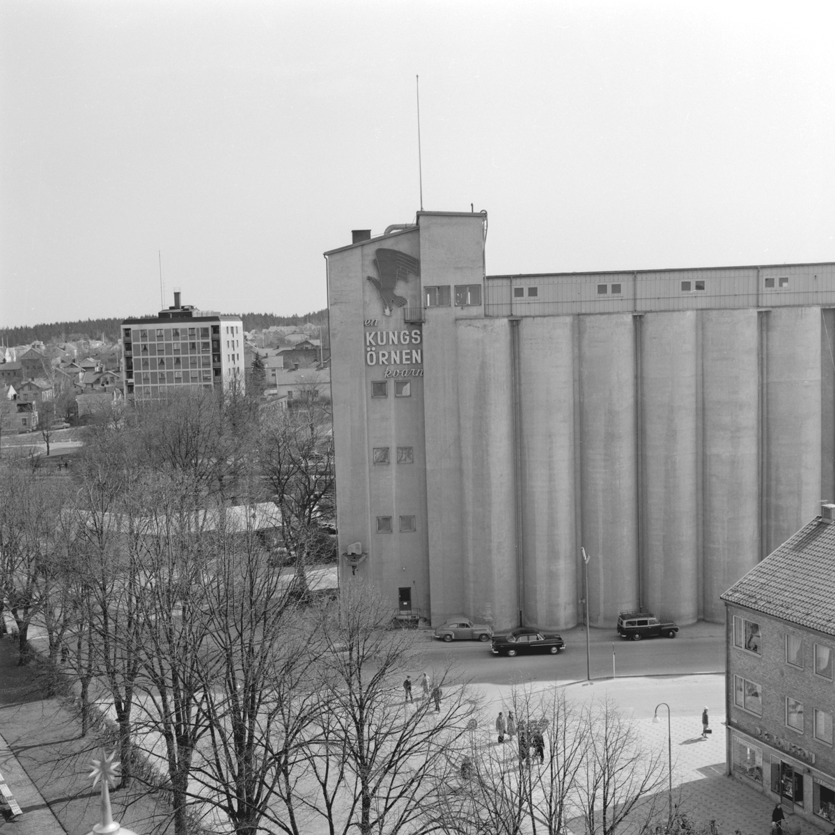 Parti av Mjölby en vårdag 1961. Utblick mot Kvarnområdet med Kungsörnens mäktiga silobyggnad. Höghuset till vänster inrymde vid tiden bland annat ortens polisstation.