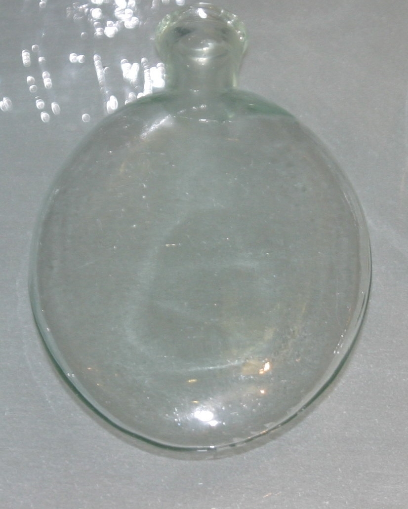 Liten, rund, flattrykt flaske i glass.