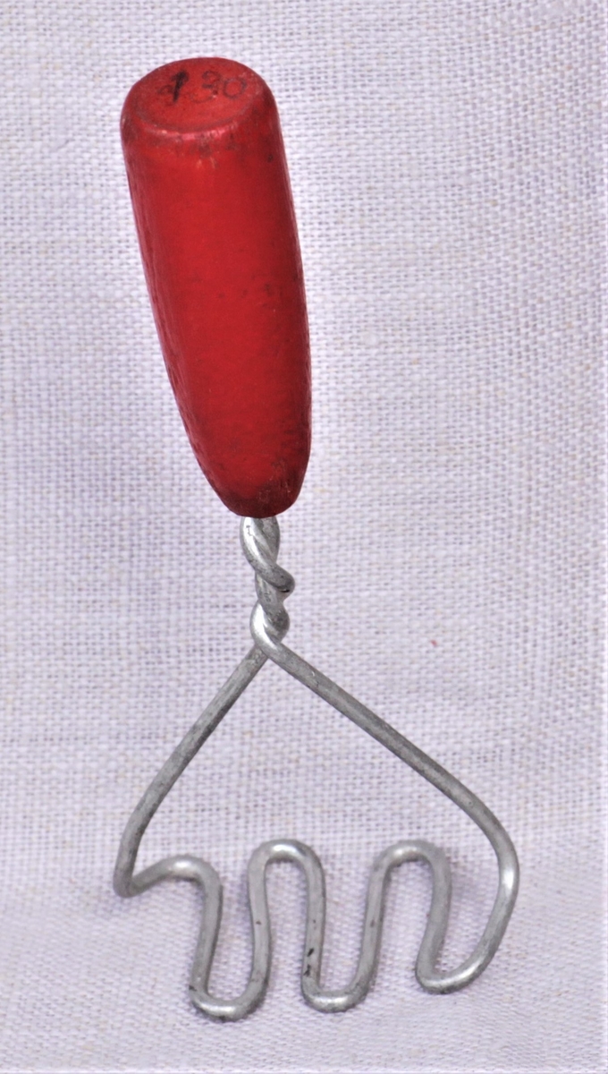 Lekepotetstapper av metall med rødt treskaft.