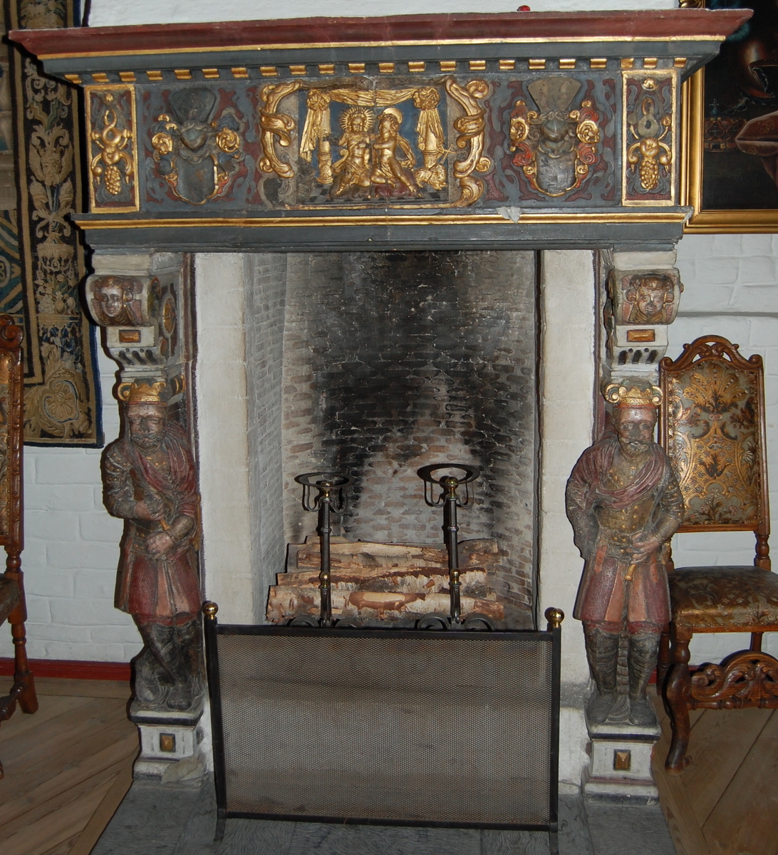 Kaminen dateres stilmessig til ca 1630-40 og har Christopher Urnes og hans hustru Sophie Lindenovs våpenskjold på gesimsen. Utskjæringer som forestiller ulike figurer både på sidene av kaminen og på gesimsen.