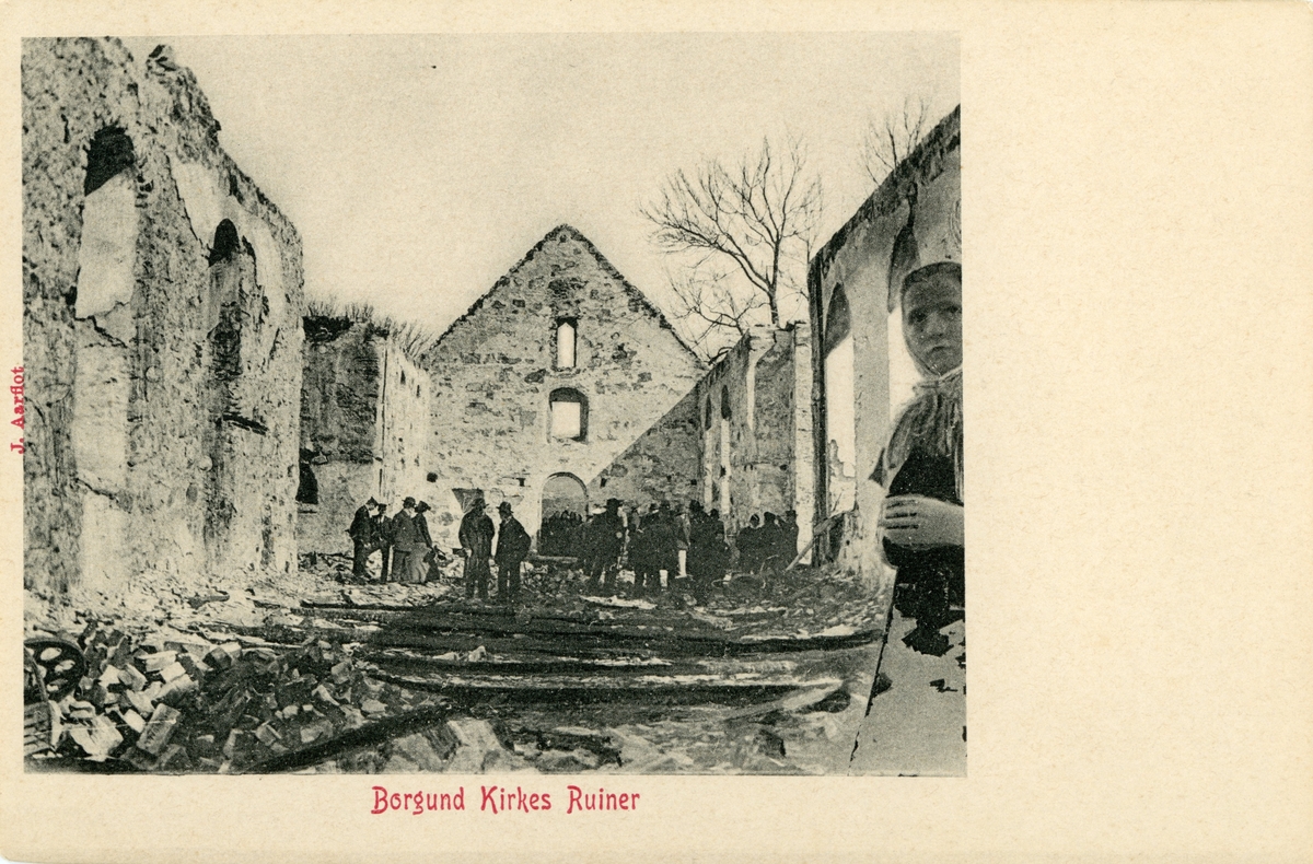 Motiv fra innsiden av Borgund Kirke etter brannen 13. april 1904. Flere mennesker står i brannruinene.