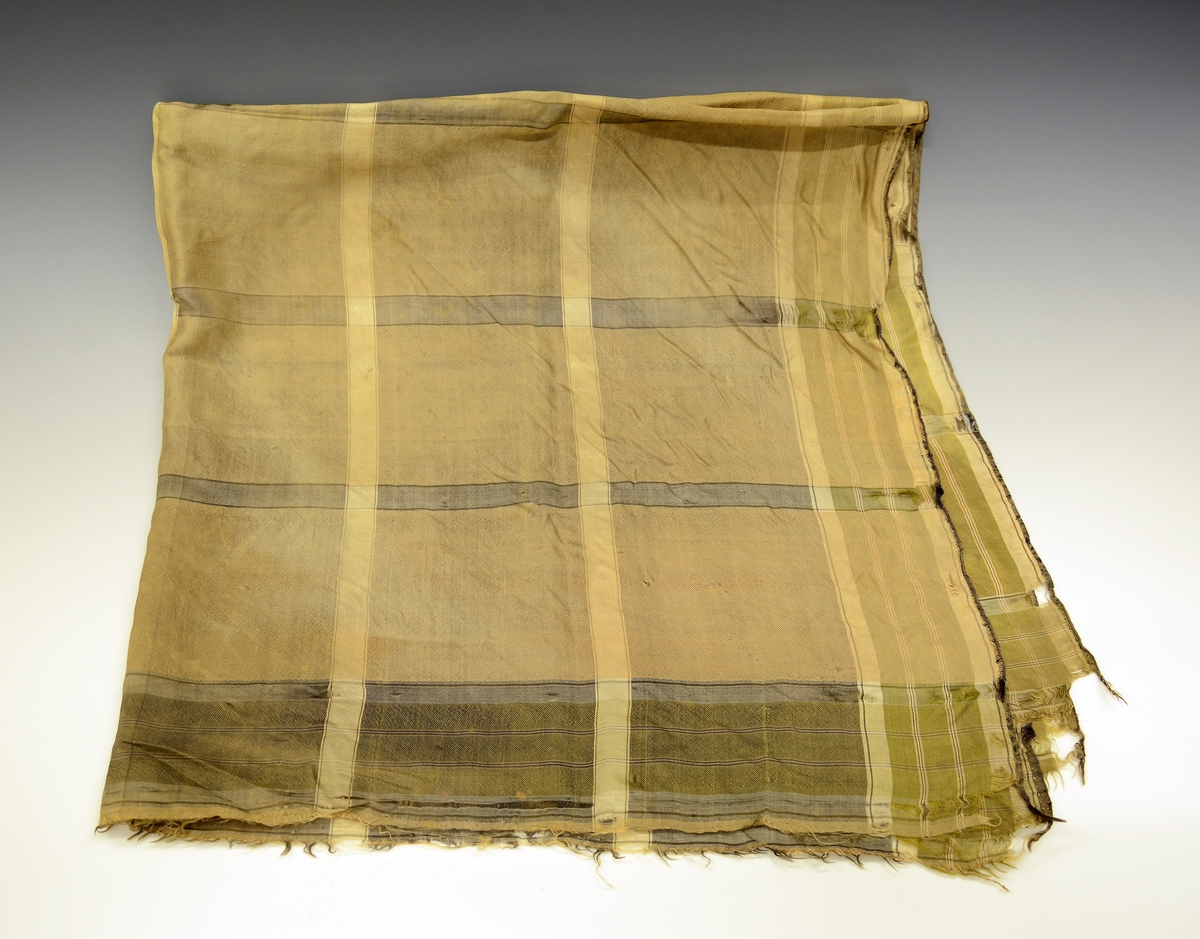 Silketørkle tilhører TGM-BM.1916-17:059 A-K.
Fra protokollen: Kvendeklædning fraa Heitdal, sauma til brurebunad i 1860-aari: F) Rutut silkeplagg til skautet.
Kvadratisk silketørkle.