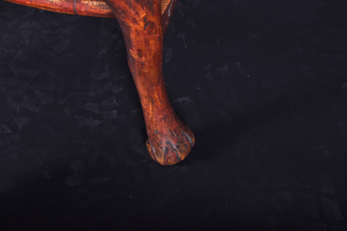Stol av björk och furu, på fyra svängda ben. Ryggen har en mittbricka i balusterform. Stolen är målad i mörkt rött och ryggbrickan har målad dekoration i rokokostil i grått och vitt.