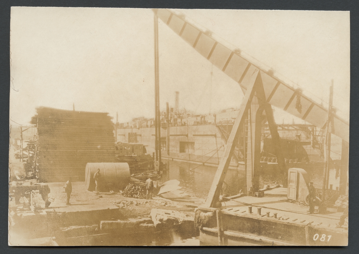 Bilden visar hamnarbetare på en kaj i Odessas hamn. Förgrunden dominera av en lyftkran och bakgrunden syns en flyttdocka.

Originaltext: