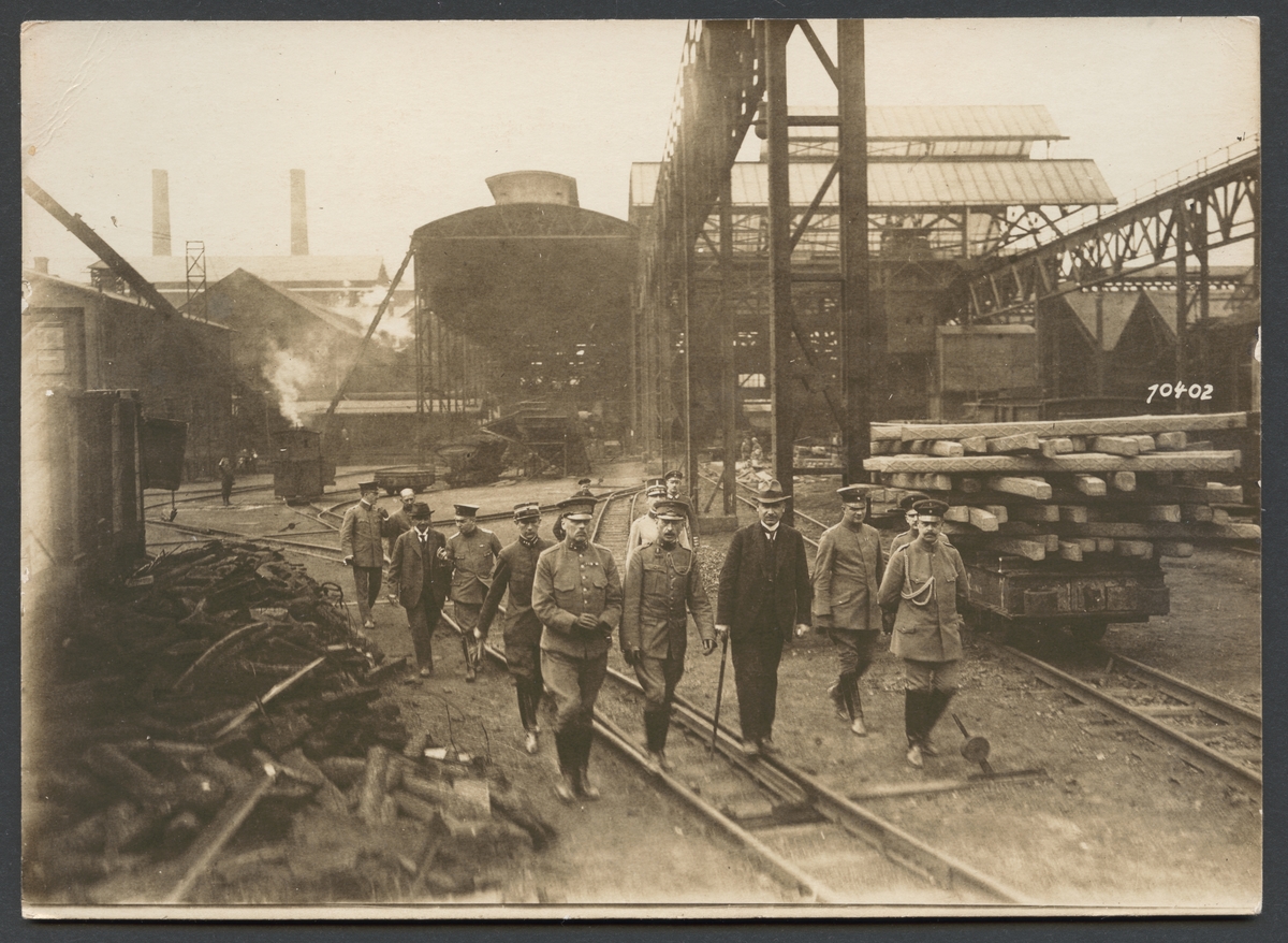 Bilden visar en grupp militärer på väg genom ett industriområde.