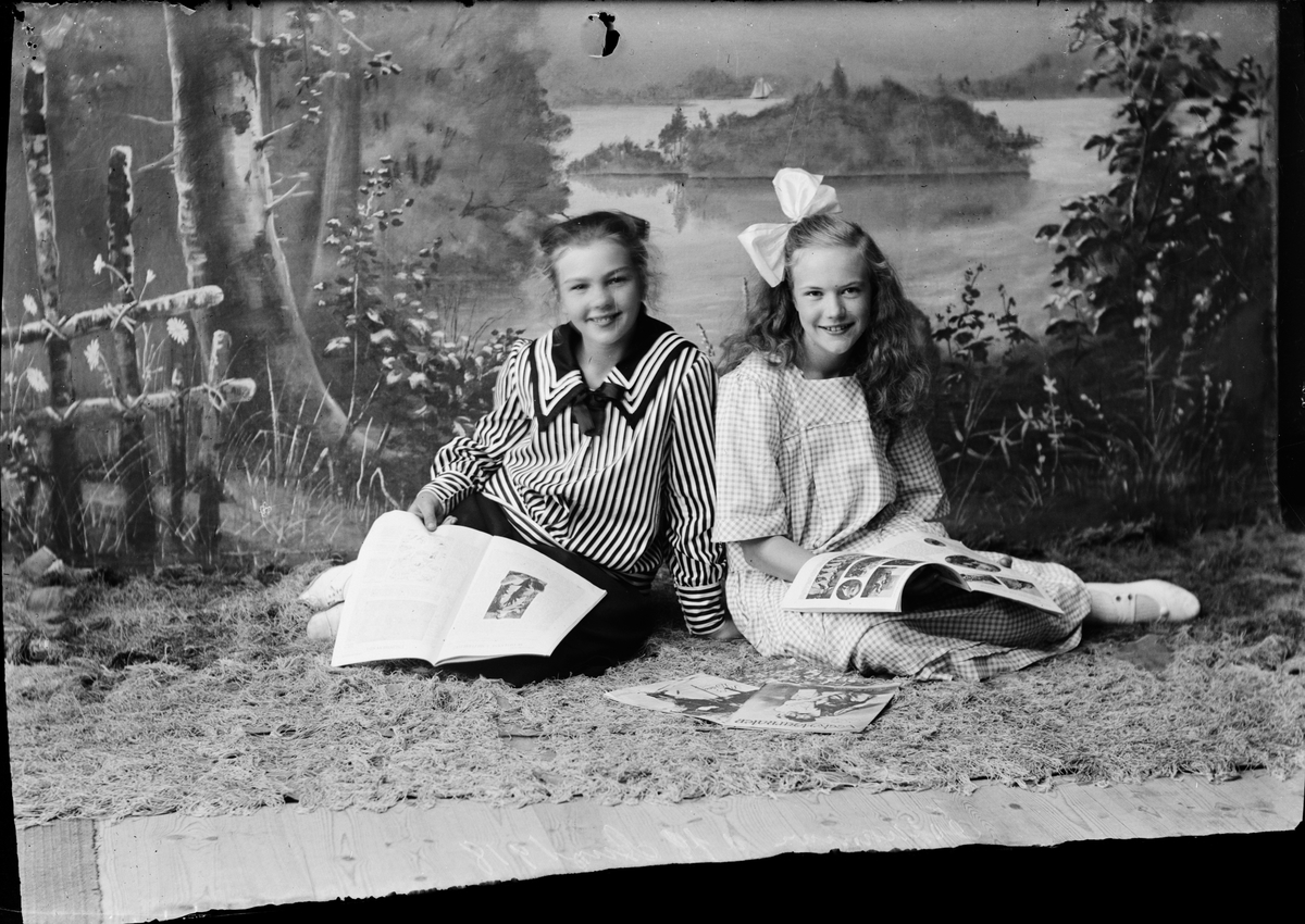 Tyra Edhlund och en flicka med varsin tidning i knät, Östhammar, Uppland