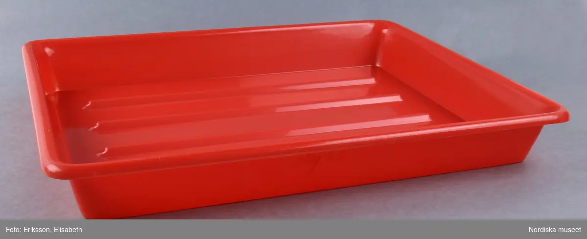 Rött kärl av hårdplast som använts som framkallningsskål av en amatörfotograf. Märkt med texten: Glyss. 
Johanna Skoglund 2013-03-25