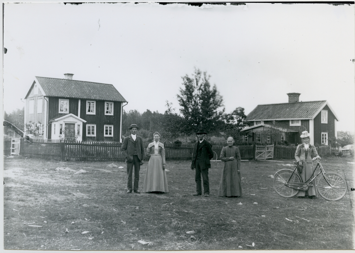 Möklinta sn, Sala.
Sunnankil. Familj och besökare framför bostadshusen. C:a 1910.