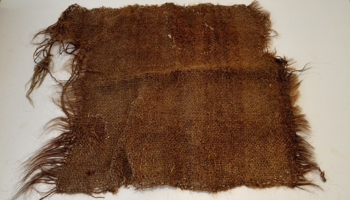 1 stykke "hæra".

Et tæppe vævet av hestehaar, benyttet som hestedekke (g.n. hæra).
Tøiets bredde er 64 cm og nuverende længde ca. 70 cm.
Gave fra gaardbruker Bjørn K. Gjeithus, Arnafjord.  