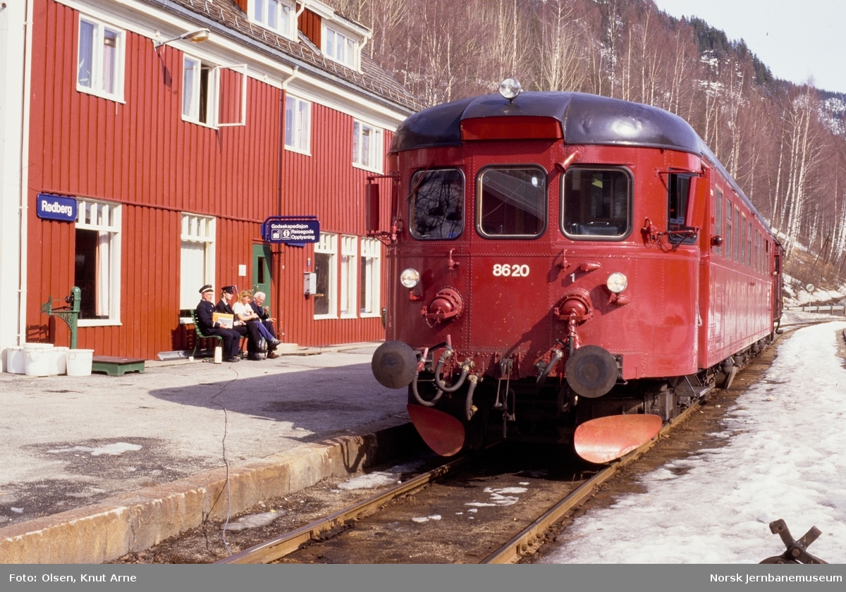 Dieselmotorvogn BM 86 20 med persontog til Kongsberg på Rødberg stasjon. Stasjons- og togpersonalet på benken foran stasjonen