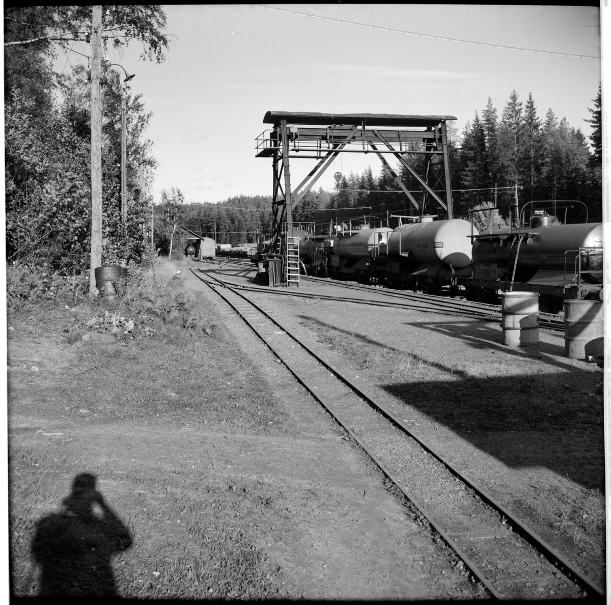 I Gyttorp.
Till höger i bild Nora Bergslags Järnväg, NBsJ 50200. Godsvagnar lastade med cisterner under traversen.