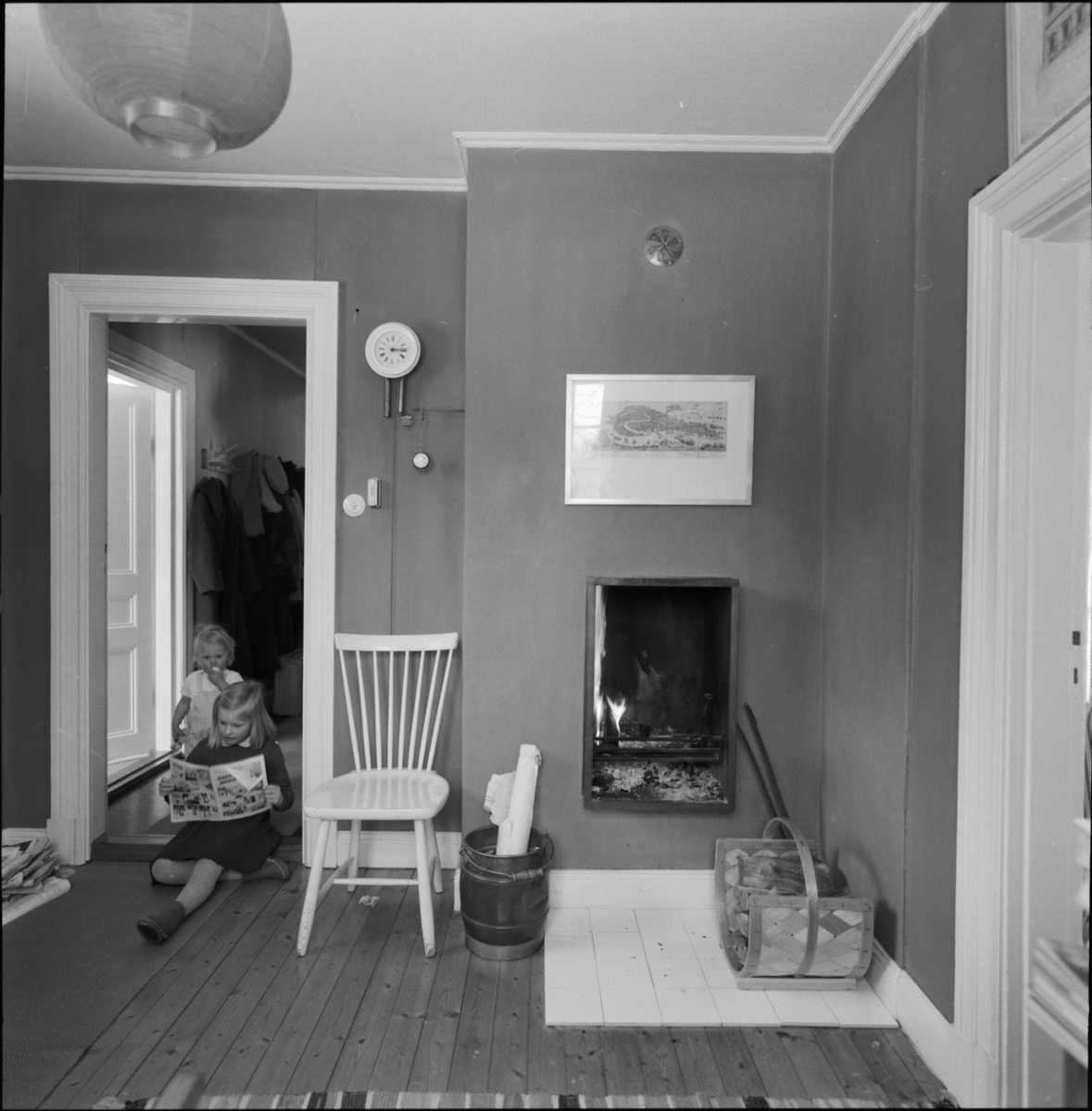 villa Ahlgren
Interiör av rum med braskamin, i dörrhålet läsande flicka