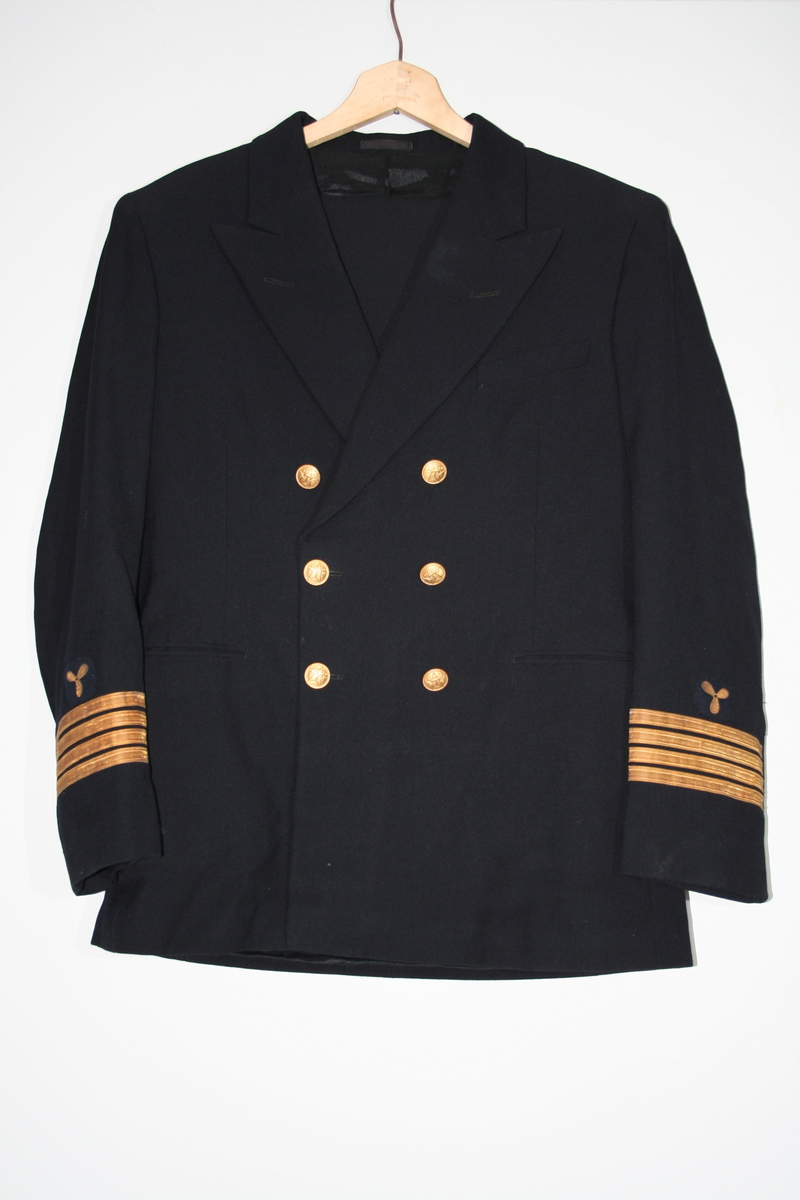 Svart uniformsjakke med to rader med tre metallknapper og distinksjoner på armene.