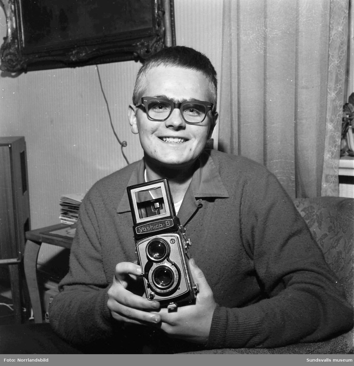 Porträttbild av Jan Bruér, med en kamera i händerna.