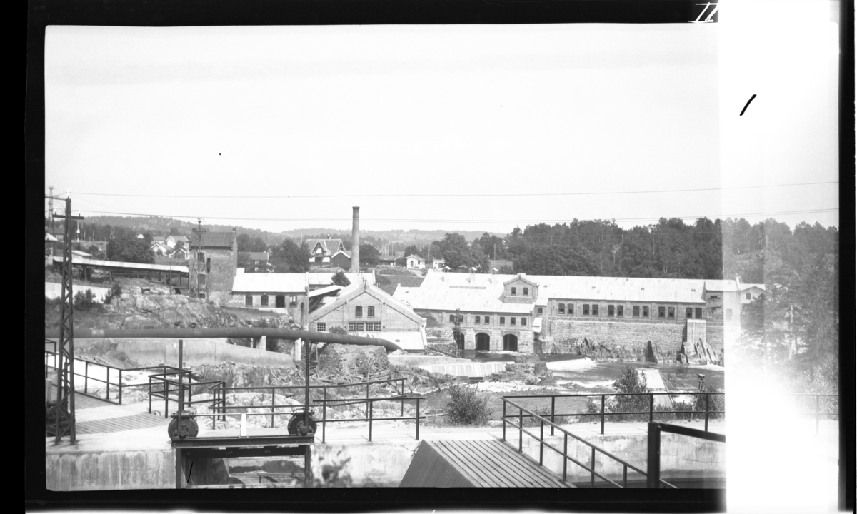 Nidelva. Gammelt sliperi til venstre, nytt til høyre. Rykene stasjon kan sees i et stykke bak fabrikken (lite hvitt hus).