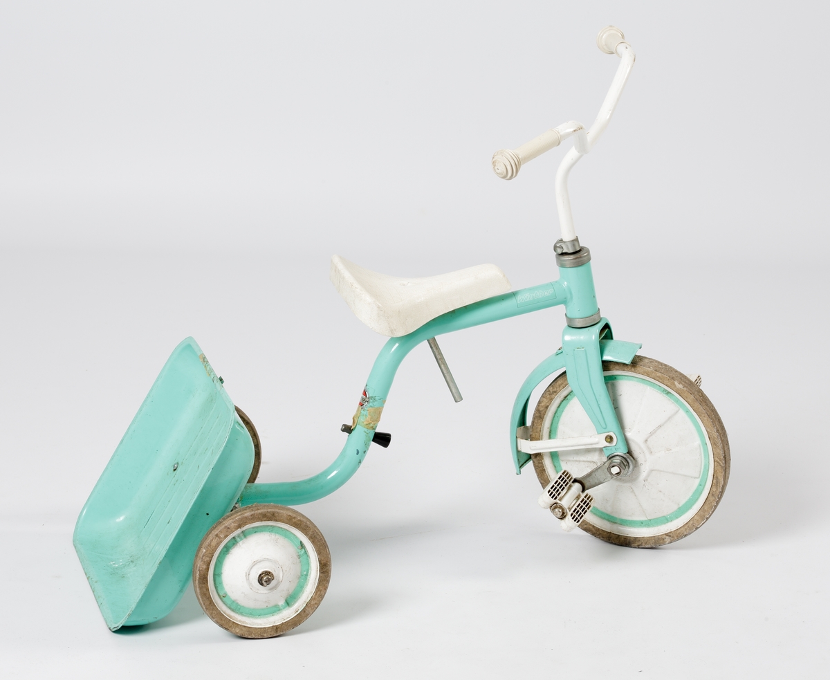 En trehjuling av stål med fällbart flak. Lackerad i mintgrönt med handtag, sits och pedaler m.m. i vit plast.