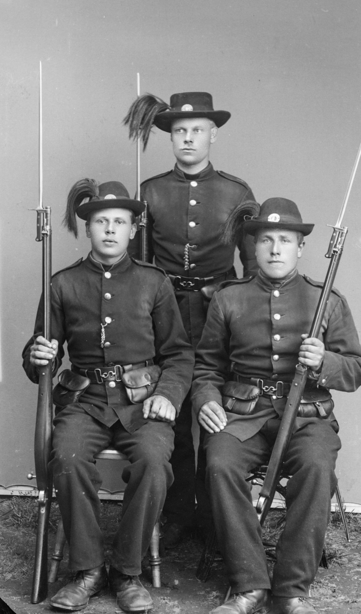 Soldater i uniform med hatt og rifler med påmontert bajonett. Antatt menige musketerer i infanteriet i hæren med unifor modell 1877. Etter MPLs regnskapsbok er dette "En gruppe  3 stk militær"