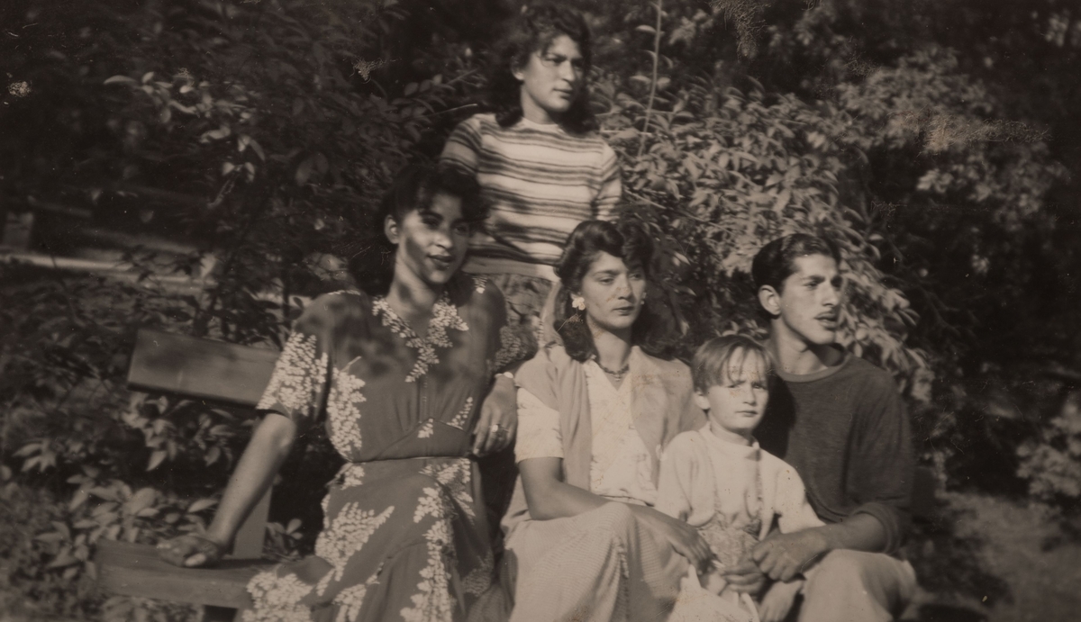 En familj är samlad kring en parkbänk för fotografering, lördagen den 12 augusti 1950 i Stadsparken i Falun.