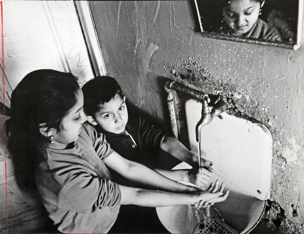 Under 1960-talet skrevs många artiklar om romska familjer som äntligen fick tillgång till fast bostad. Här syns två syskon som tvättar händerna vid ett handfat med rinnande vatten.