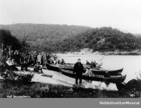 Gruppe av mennesker ved elvebåter på Øvrevann. Stortingets samferdselskomité på befaring, 1923.