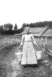 NIna Sørensen bærer vann, ca. 1920-1930. Opplysning 1996 fra