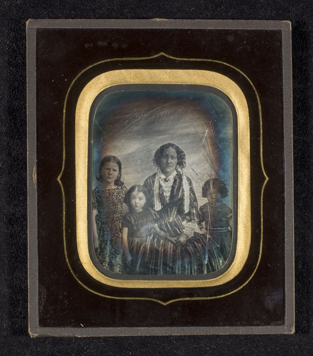 Daguerreotypi av kvinne med tre barn.