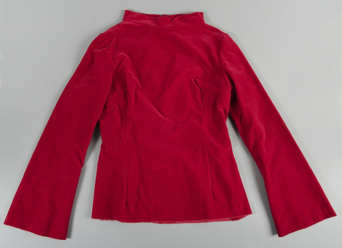 Överdel till aftonklänning i röd sammet. Ingår i tredelad klänning tillsammans med kjol UM43439b och skärp UM43439c. Långärmad och ståkrage. Insydd. Dragkjedja i ryggen. Utställda ärmar.
