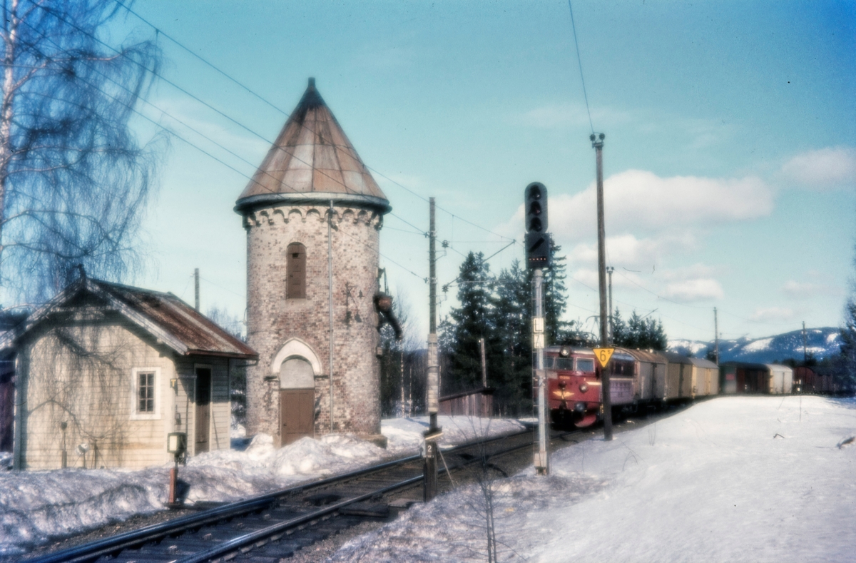 Vanntårneet på Stryken stasjon på Gjøvikbanen. I bakgrunnen elektrisk lokomotiv El 13 med godstog