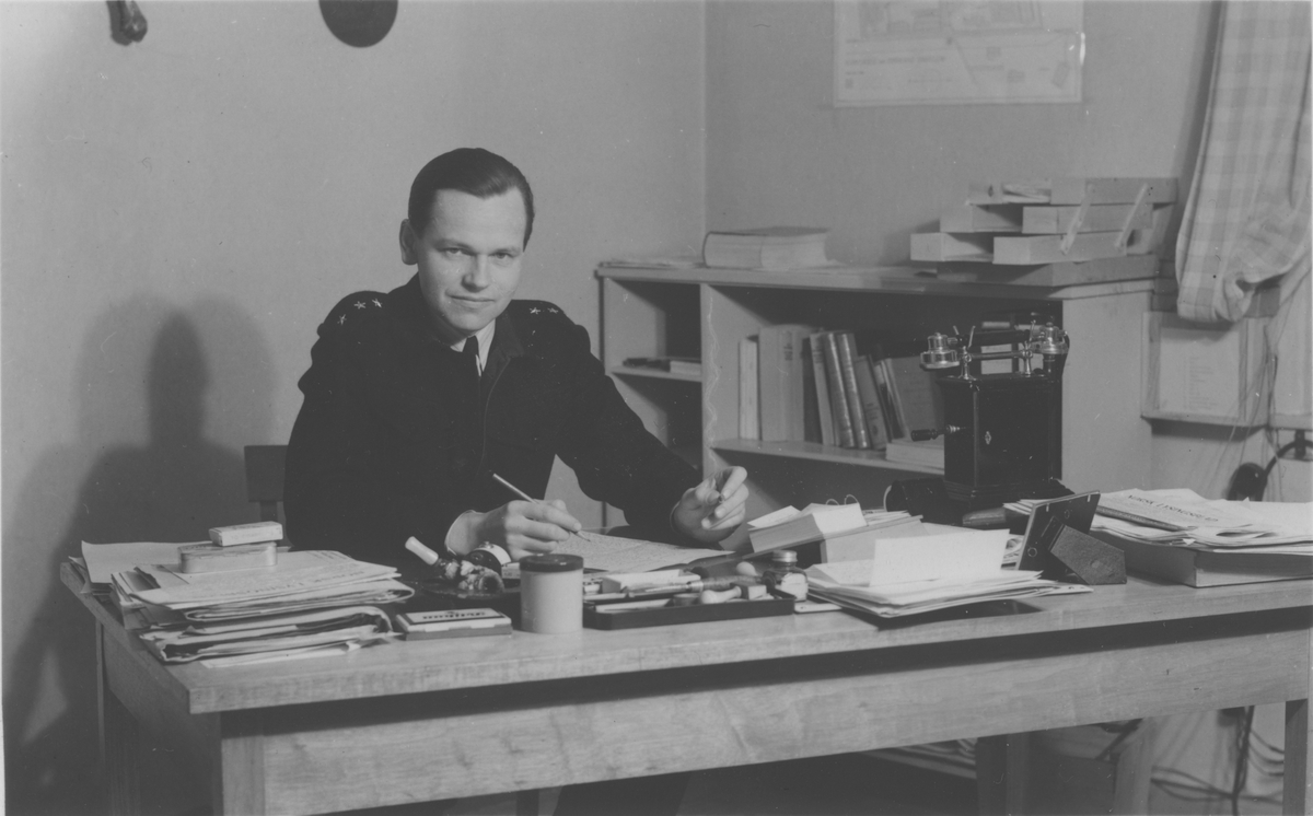 Interiør i Innherad fangeleir (tvangsarbeidsleir) 1946-47. Kjeld Bugge (f. 1912 i Kongsberg, d. 1990) ved skrivebordet. Han var fengselsdirektør i Trondheim 1946-49, og dermed også direktør for Innherad tvangsarbeidsleir.