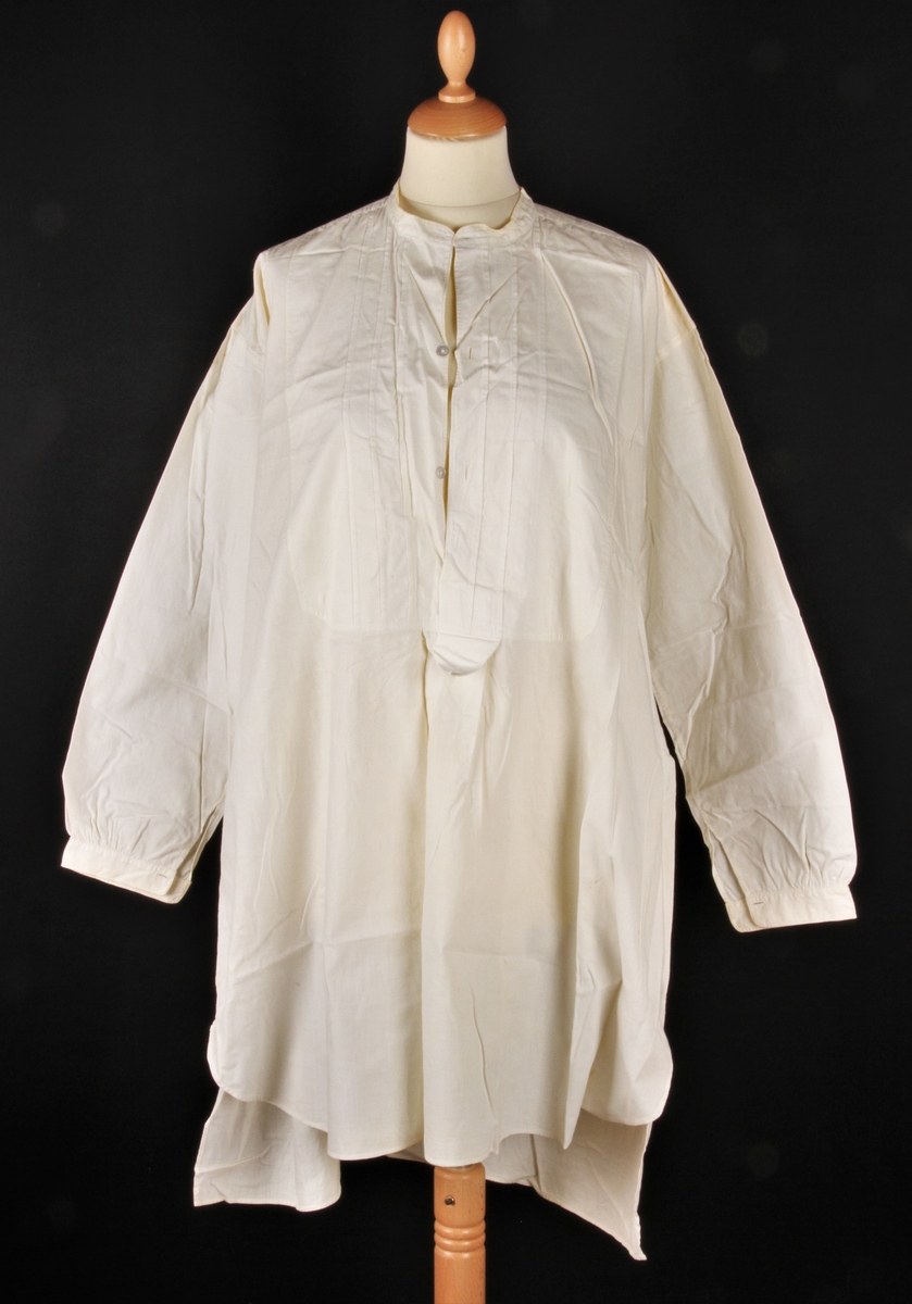 Nattskjorte med bærestykke, sydd i bomull, lang med lang erm, knapper foran og på ermene.