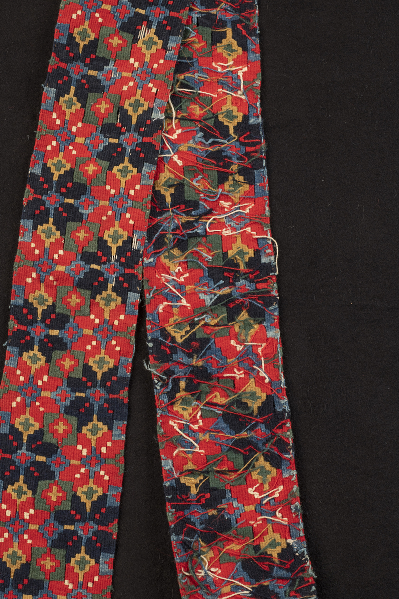 Stakkebord i smettebandsveving. Mønster med to rader av åttebladsroser i vekselvis rødt og mørk blått. Borden var utstilt ved Noregs Bygdekvinnelags tekstilutstilling i Oslo, 1953.
