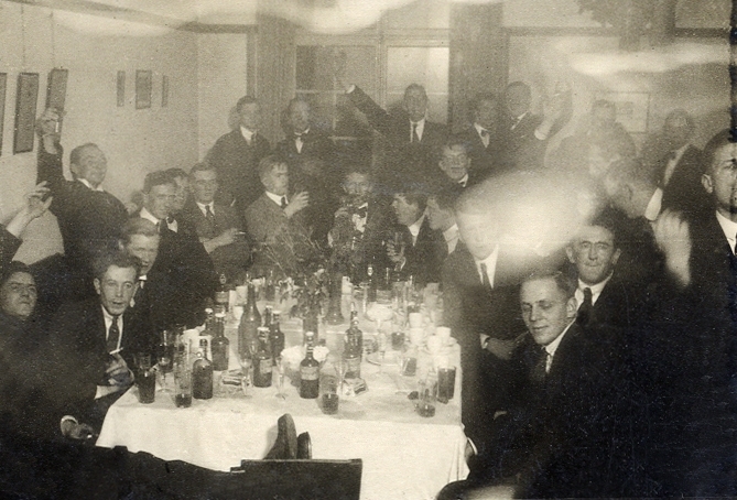 Ett sällskap glada unga herrar i en festlokal.
Under fotot text: " - Valborgsmässoafton - började alltid - med en kärleks - måltid på Kåren -".