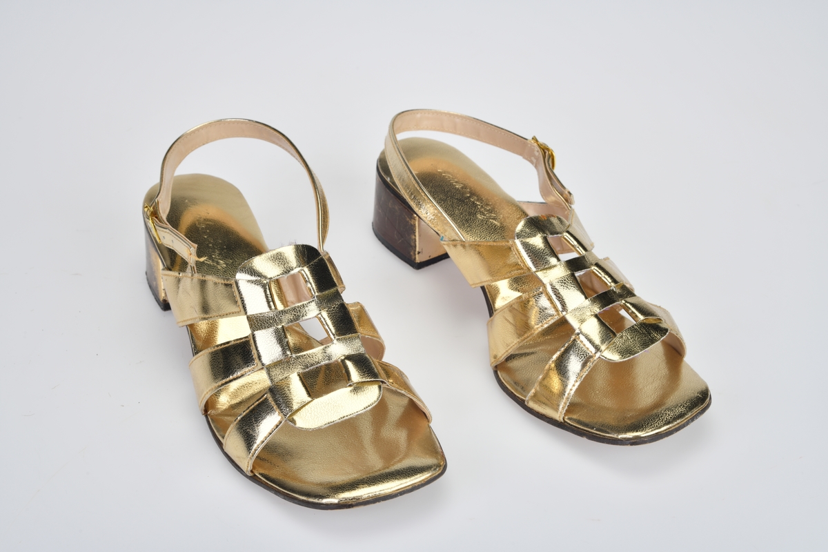 Skoene er typisk for 1970-tallets selskapssko. Skoene likner mer sandaler med 3 reimer fra hver side av skoen som møtes/flettes sammen i et midtparti som er 4,5cm brest og 8cm langt. Reimene er foret med beige plast. Innersålen er av gullfarget plast. Yttersålen er av brunt lær, mens hæelen er av svart plast. Det er en liten gullspenne (av metall) i åpning på utsiden av hælen.