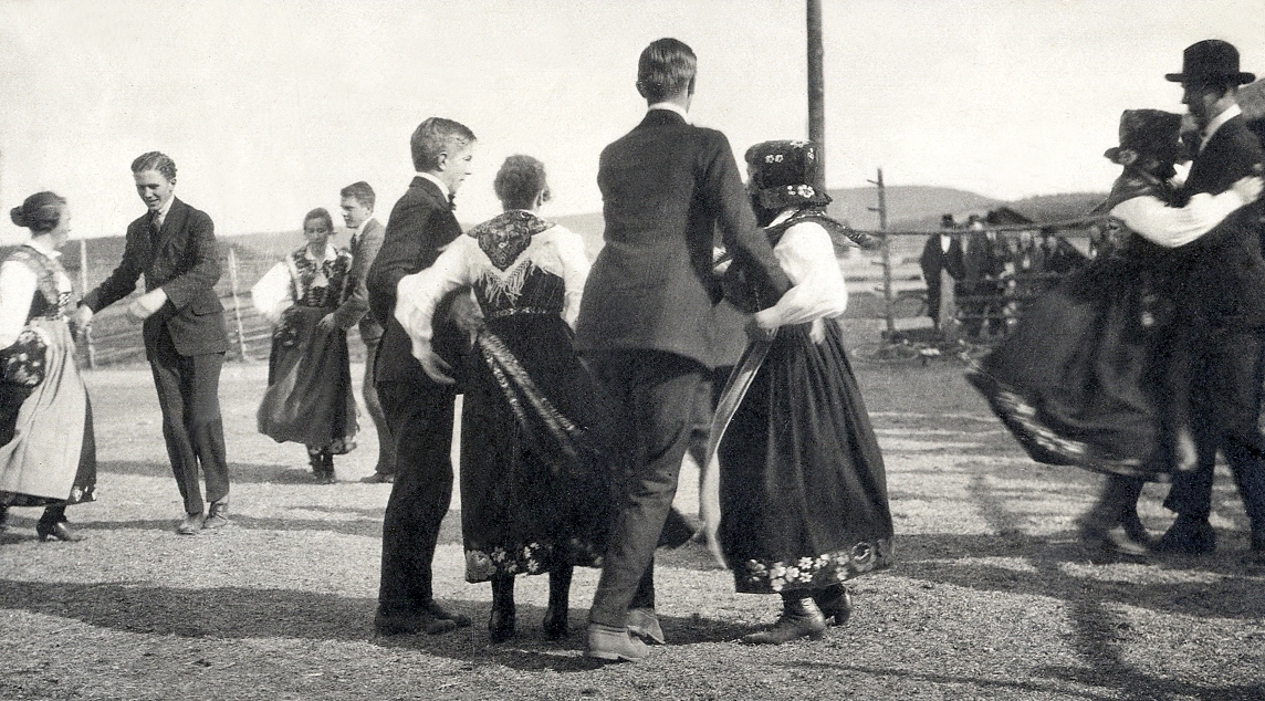 Ett antal unga män i kostym dansar med några unga kvinnor i folkdräkt.
Vid fotot text:
" - Men på eftermiddagen dansade - vi med kullorna - i Björbo -". 
På föregående sida rubrik: "- STUDIERESAN -".