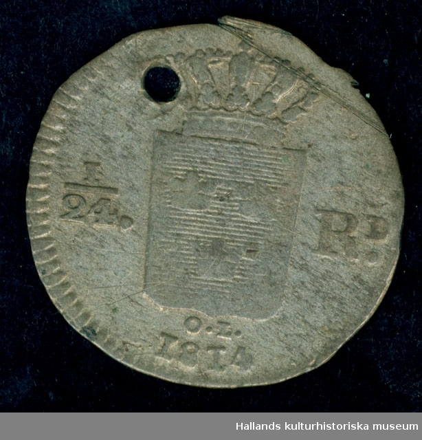 Silvermynt med stansat hål. 1814. Carl XIII:s krönta monogram. Se bild. Diameter: 2,1 cm. 1/24 RD.