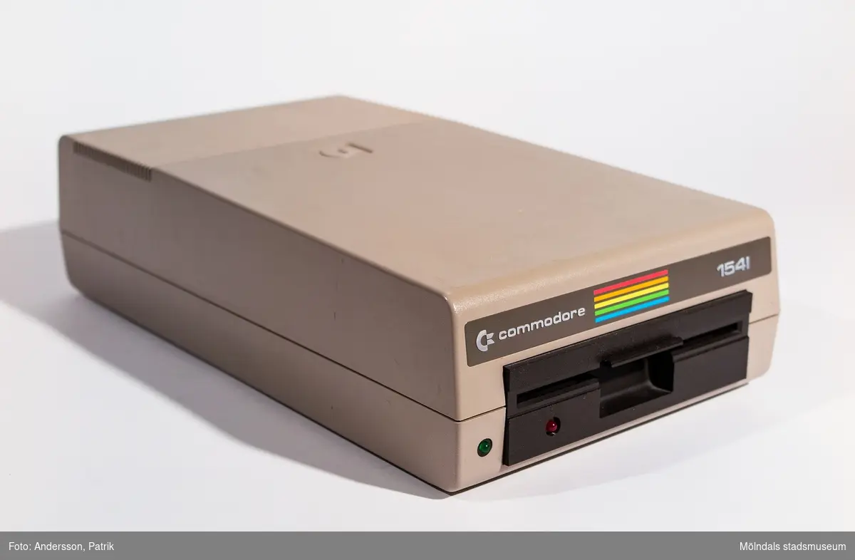 Diskettstation Commodore 1541. 
Beigefärgat plasthölje med logotypen med ränder i regnbågens färger och modellnamn Commodore 1541.
Diskettstationen är gjord för 5 1/4"-disketter.