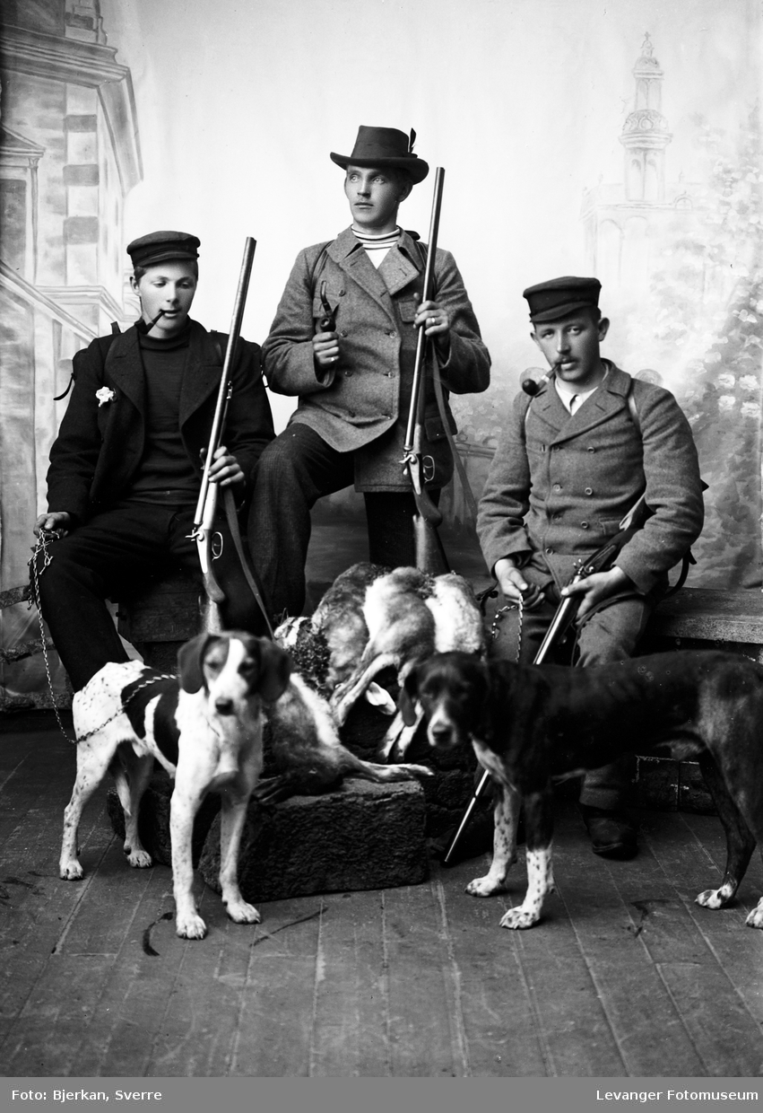 Gruppebilde av jaktlag med hunder og våpen.