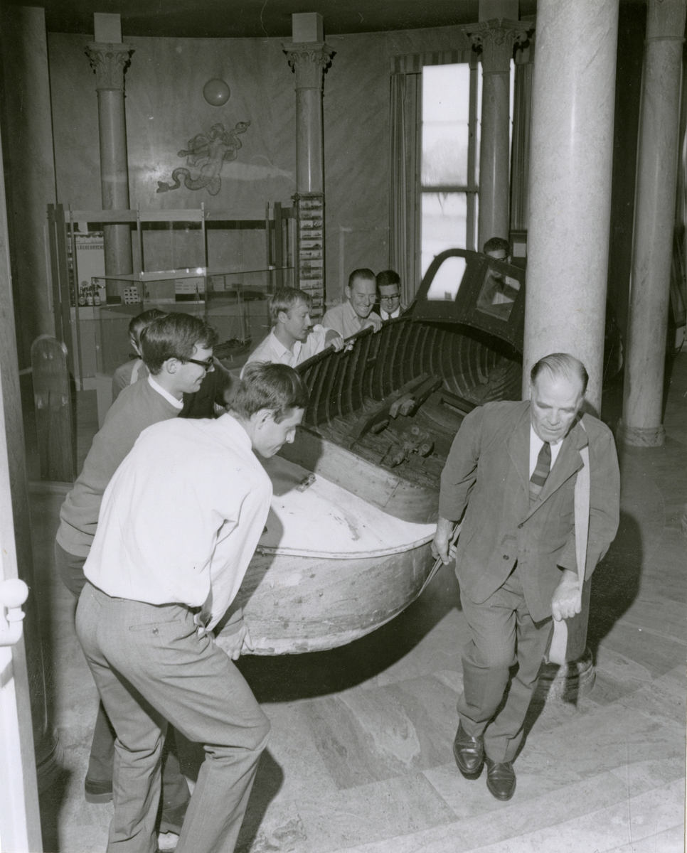 Motorbåten DIXIE flyttas i Sjöhistoriska museets lokaler i samband med utställningen "Framtidens nöjesbåt" år 1968.