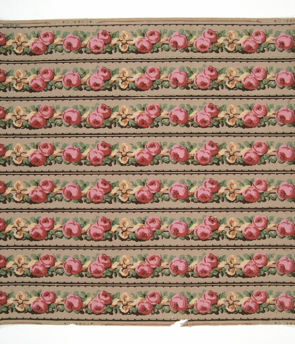 Oskurna tapetbårder med mönster i form av en stav, omlindad med en rosengirland och prydd med bandrosetter. Tryck i rött, rosa, grönt och nyanser av brunt på tryckt s.k. patentbotten. IB